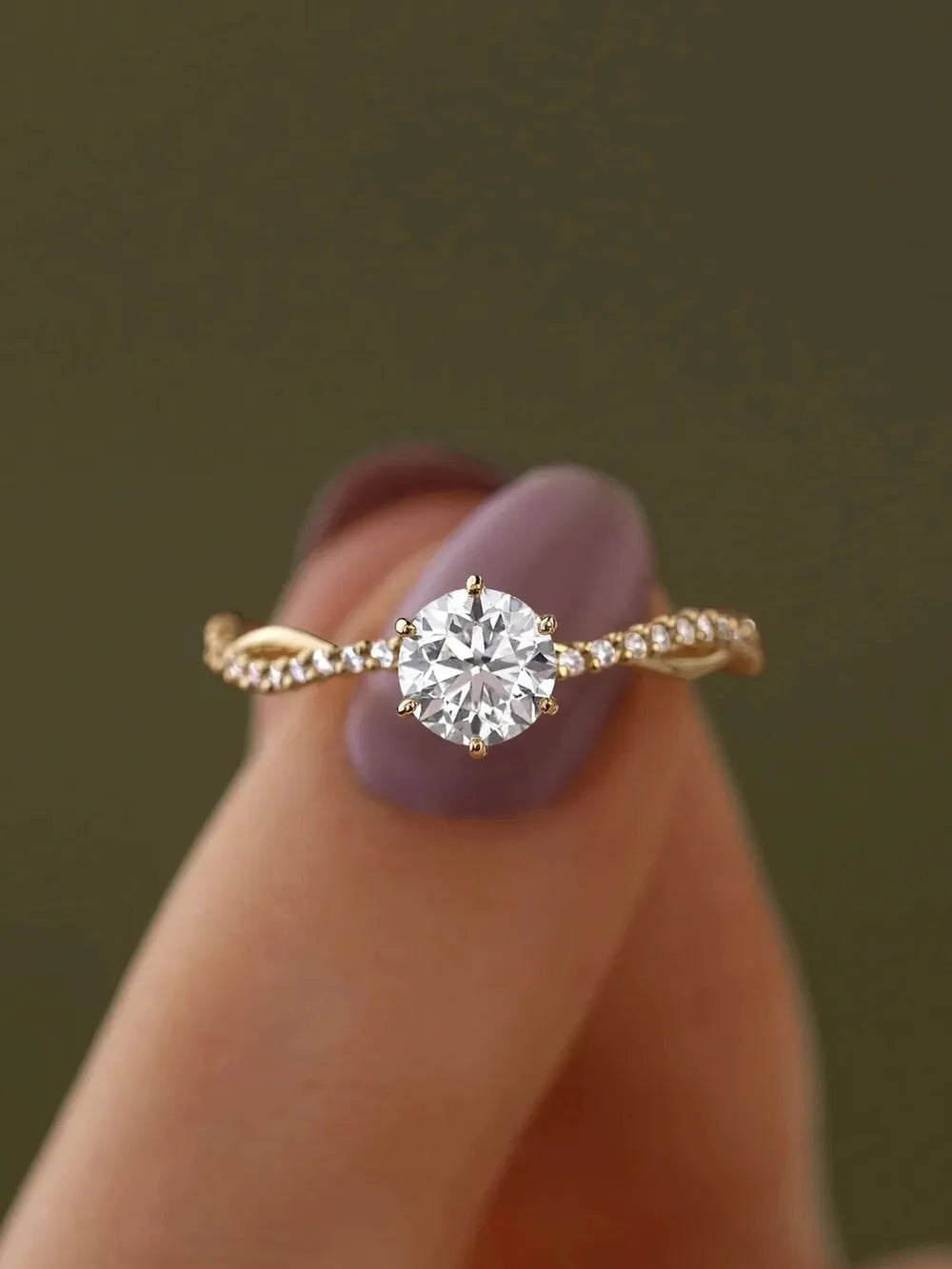 Gold engagement ring with twisted pavé zircon band and solitaire diamond.