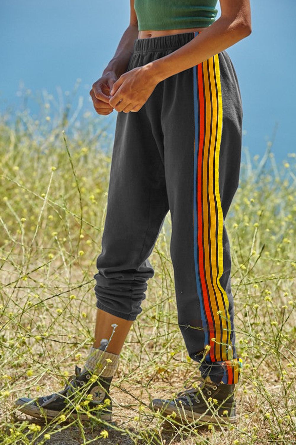 Gray track pants with rainbow stripe detail on the side