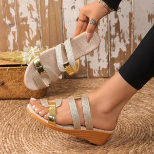 Glistening dual-strap wedge sandals in gold and silver with a cork wedge heel.