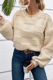 Beige textured checkerboard knit sweater with crew neck and long sleeves.