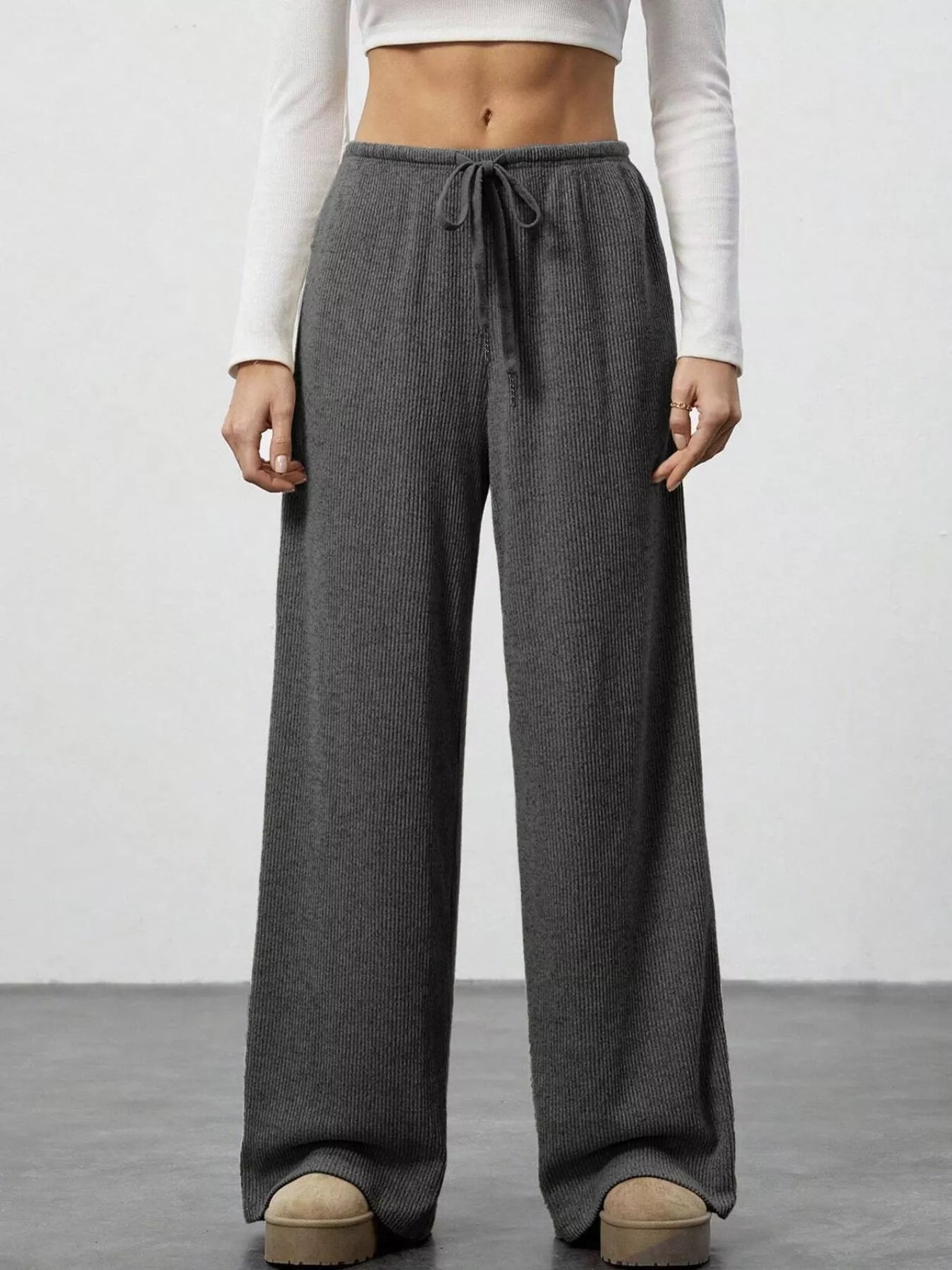 Dark gray ribbed wide-leg pants with drawstring waist and relaxed fit.