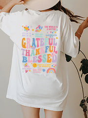 White graphic tee with colorful "Grateful Thankful Blessed" text and affirmations.