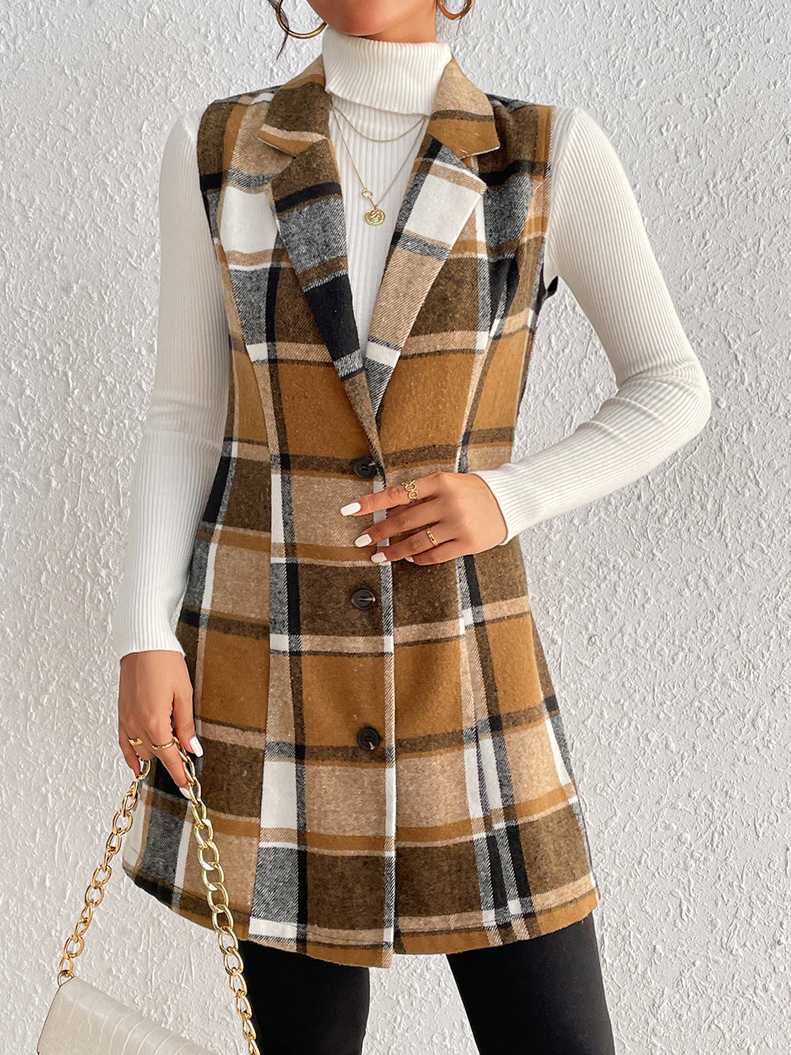 Camel plaid blazer vest with tailored silhouette and button front, worn over a white turtleneck.
