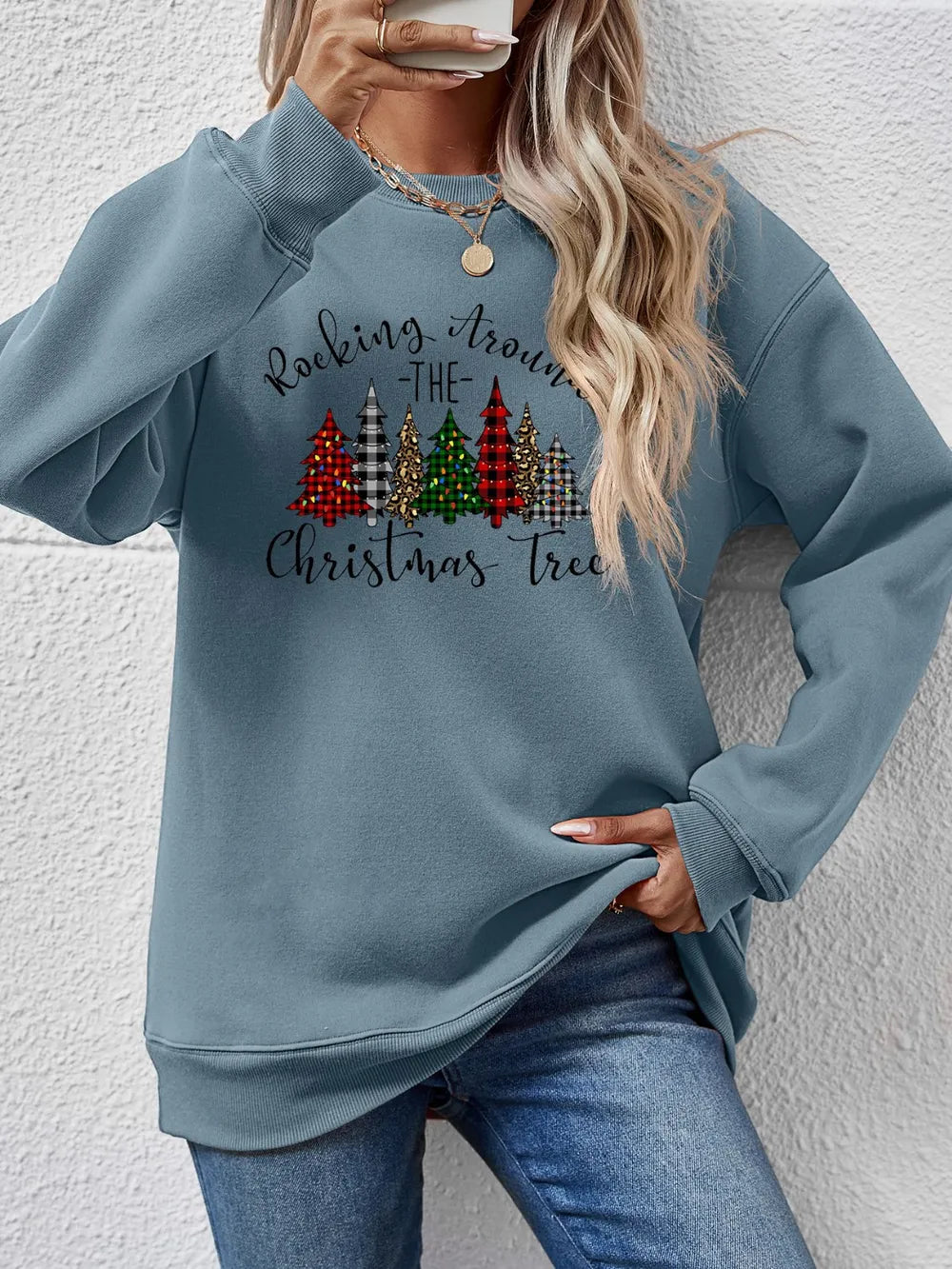Misty Blue crewneck sweatshirt with a graphic Christmas tree print and text that reads Rocking Around the Christmas Tree.