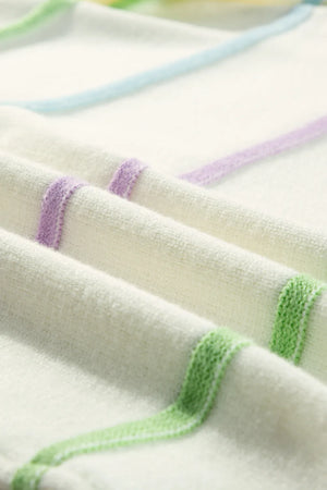 Ivory knit henley sweater with pastel stripes in purple, blue, and green.