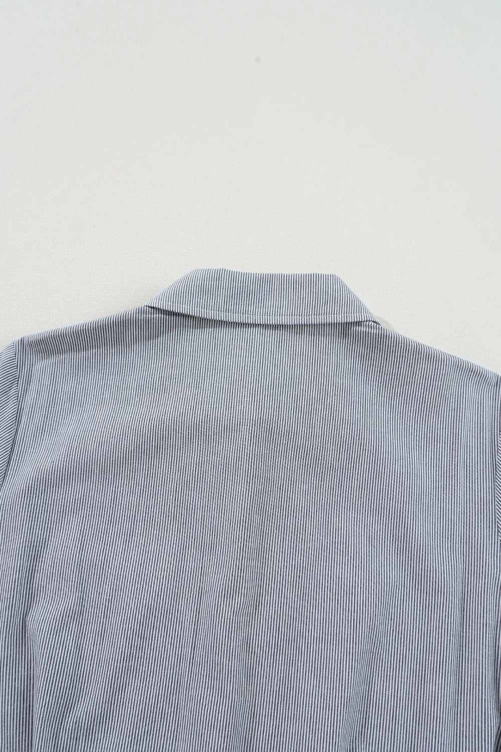 Pinstripe shirred waist romper with tie, close-up of collar and upper back.