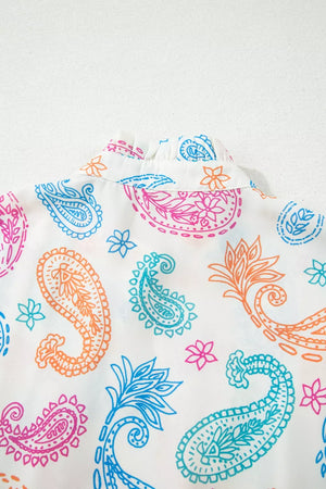 Maternity blouse with vibrant paisley print, ruffled collar, and puff sleeves.