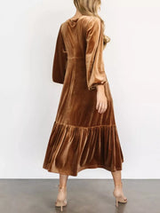 Gold velvet midi dress with tiered skirt and balloon sleeves.