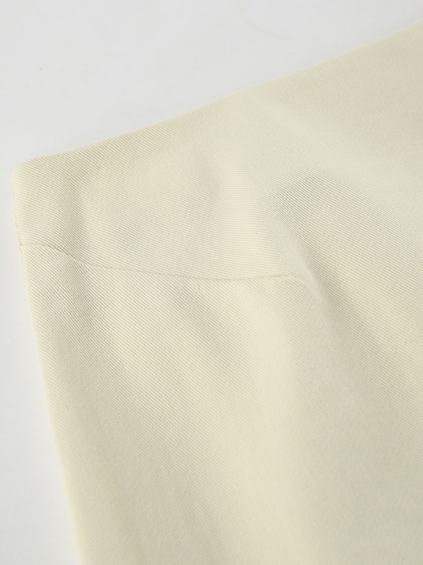 Chic cotton midi skirt in beige, featuring a subtle ribbed texture and a side slit detail.