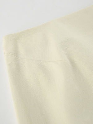 Chic cotton midi skirt in beige, featuring a subtle ribbed texture and a side slit detail.