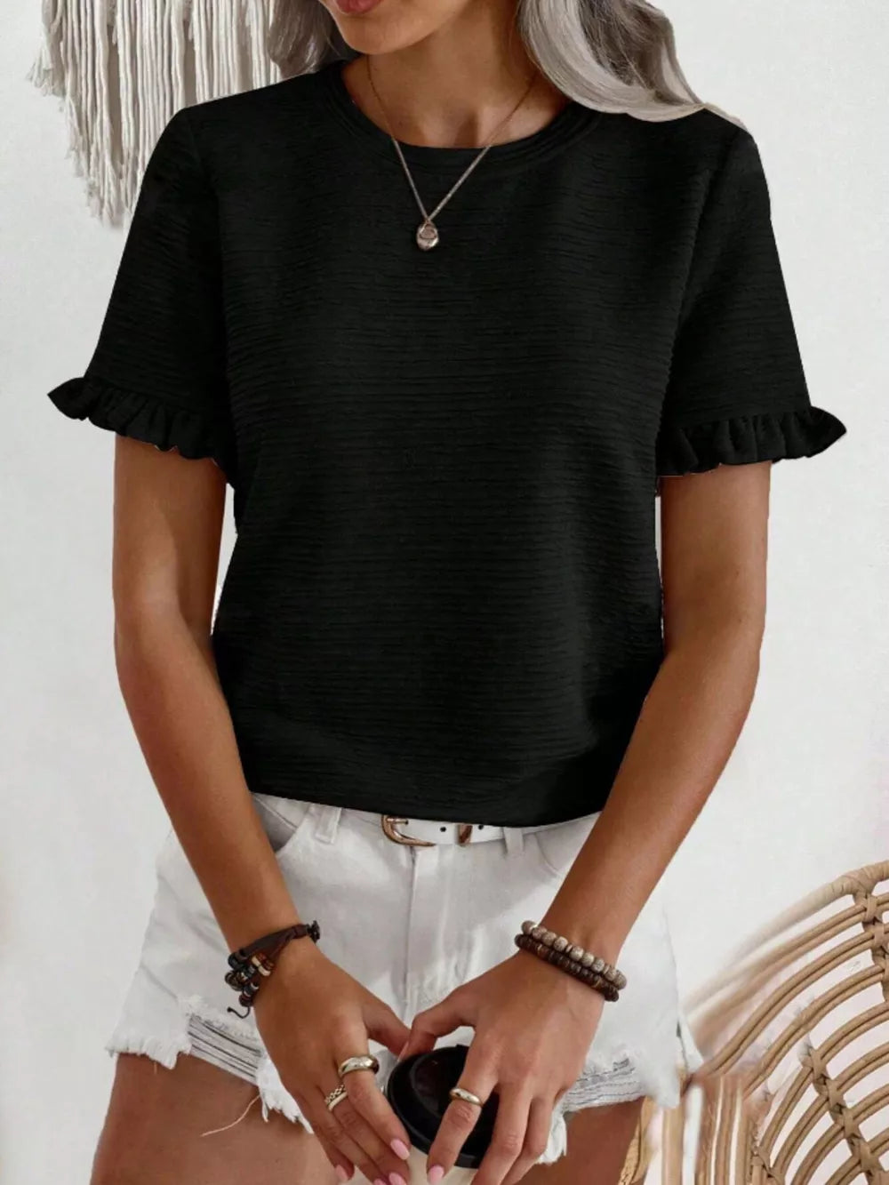 Black textured t-shirt with ruffle cap sleeves and crew neck.