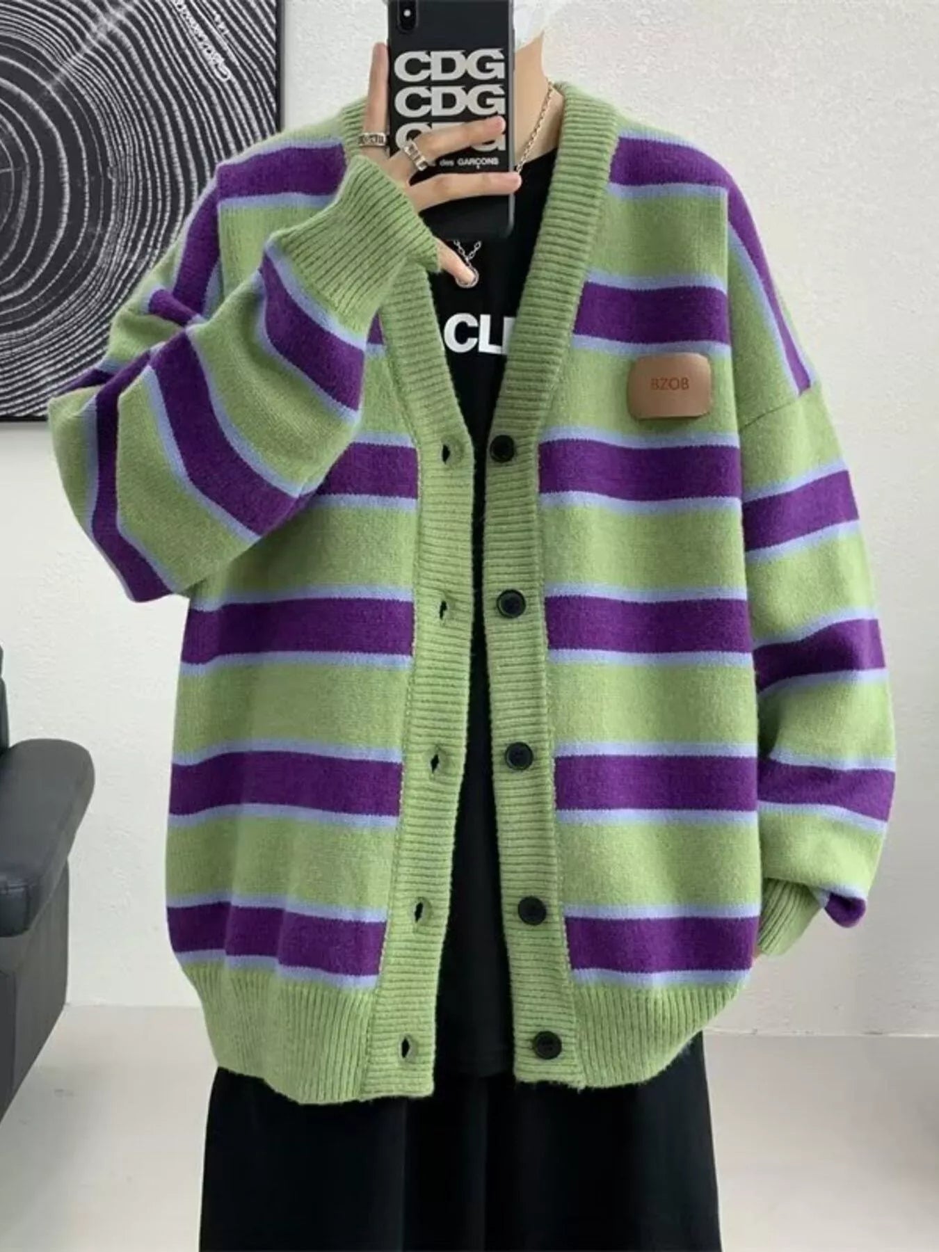 Oversized green striped V-neck cardigan with buttoned front and patch detail.
