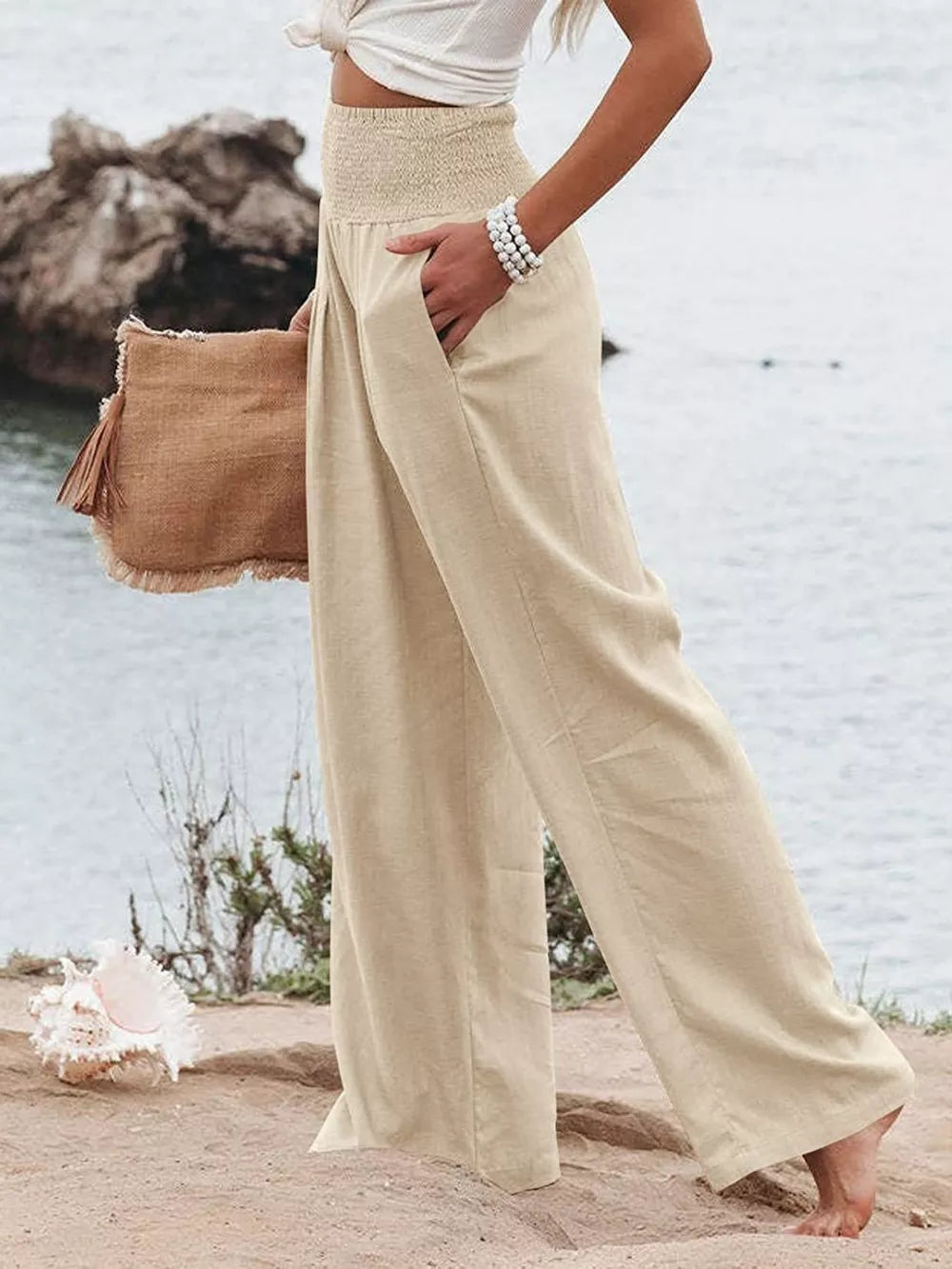 Tan smocked wide-leg maternity pants with pockets, styled casually.