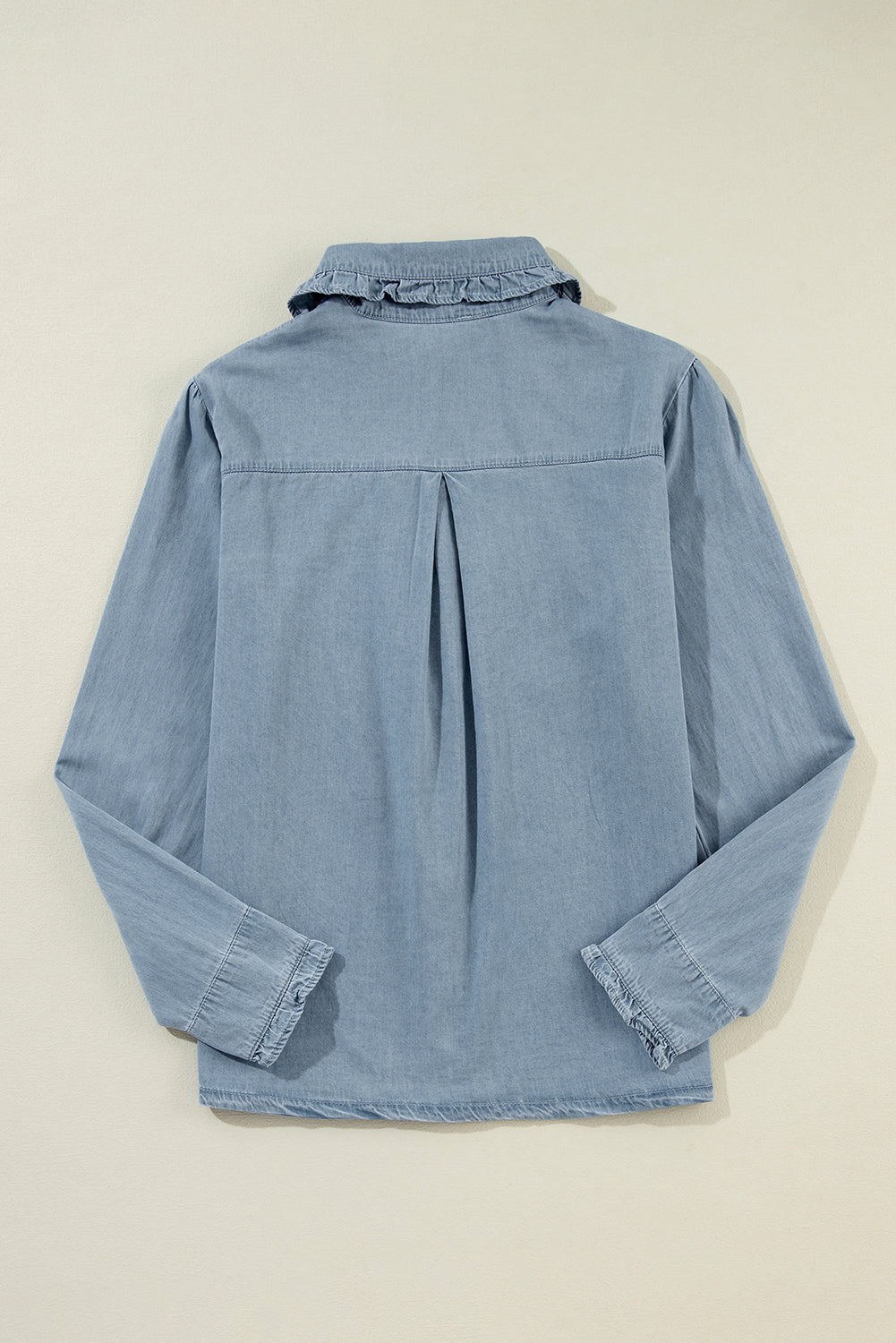Indigo button-up blouse with ruffled collar and frayed hem.