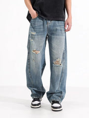 Men's distressed wide-leg jeans in washed blue denim with ripped details.