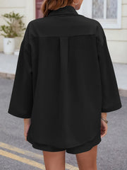 Black oversized button-down shirt with pleated back detail and matching shorts.