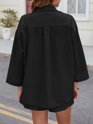 Black oversized button-down shirt with pleated back detail and matching shorts.