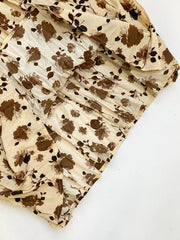 Botanical pleated midi skirt in tan with a brown floral print and crinkled texture.