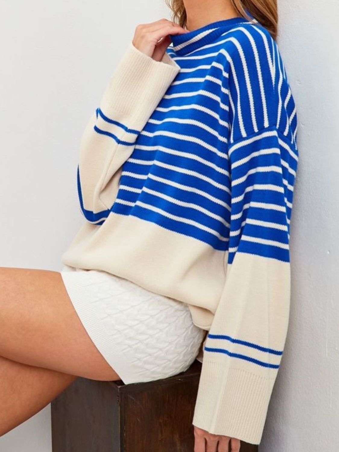 Colorblock stripe knit sweater with bell sleeves in blue and cream.