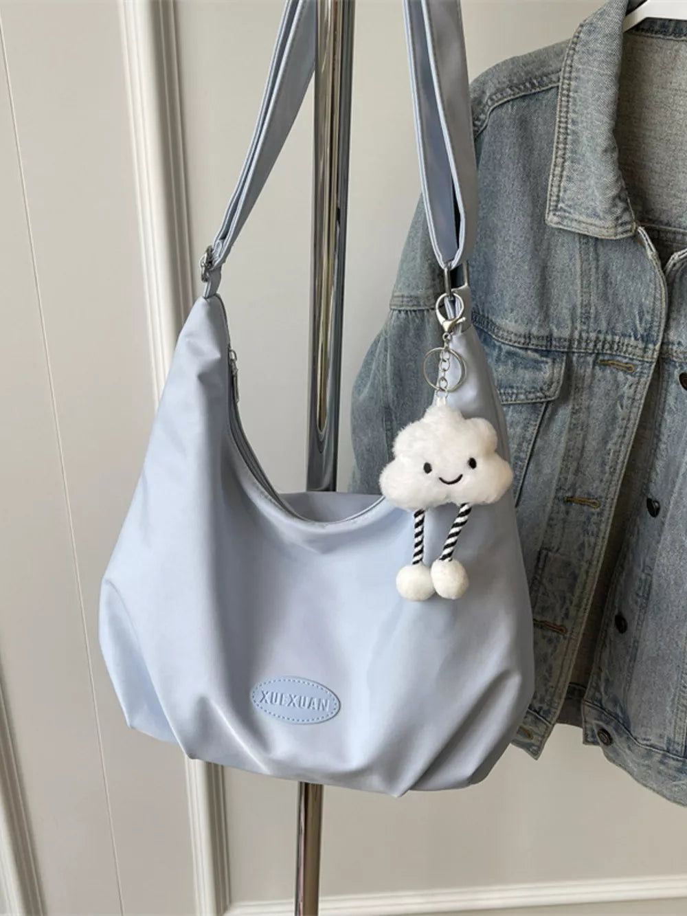 Light blue canvas shoulder bag with adjustable strap and cute cloud charm.
