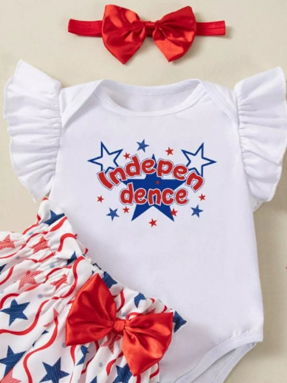 Baby girl Independence Day outfit set with ruffled sleeves, star print bloomer, and red bow headband.