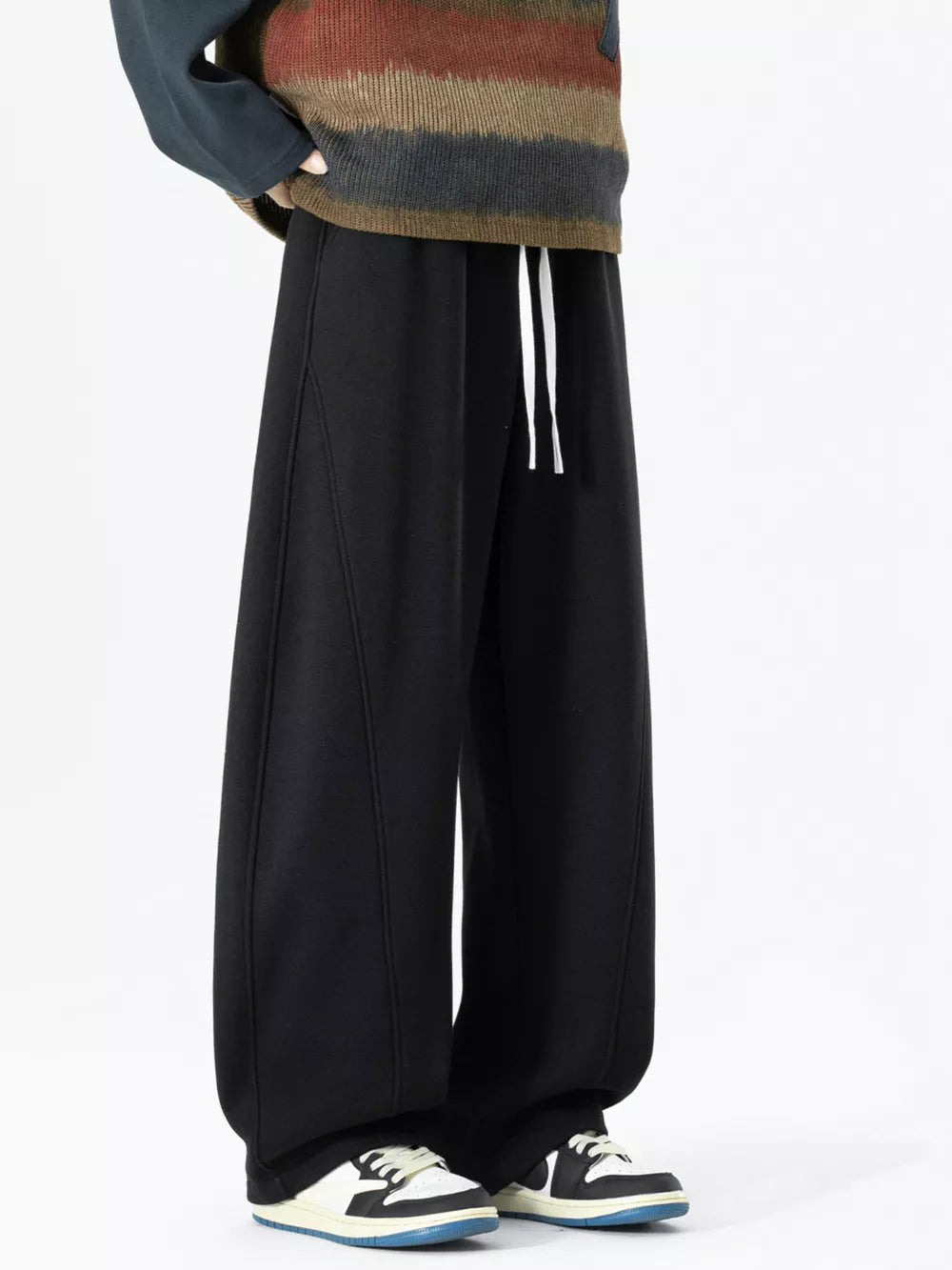 Black wide-leg sweatpants with drawstring and visible stitching detail.