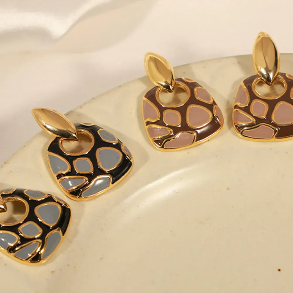 Geometric enamel drop earrings in black and brown with gold accents.
