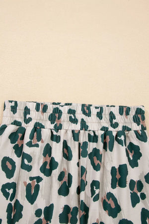 Pajama pants with elastic waist and green leopard print on polyester fabric.