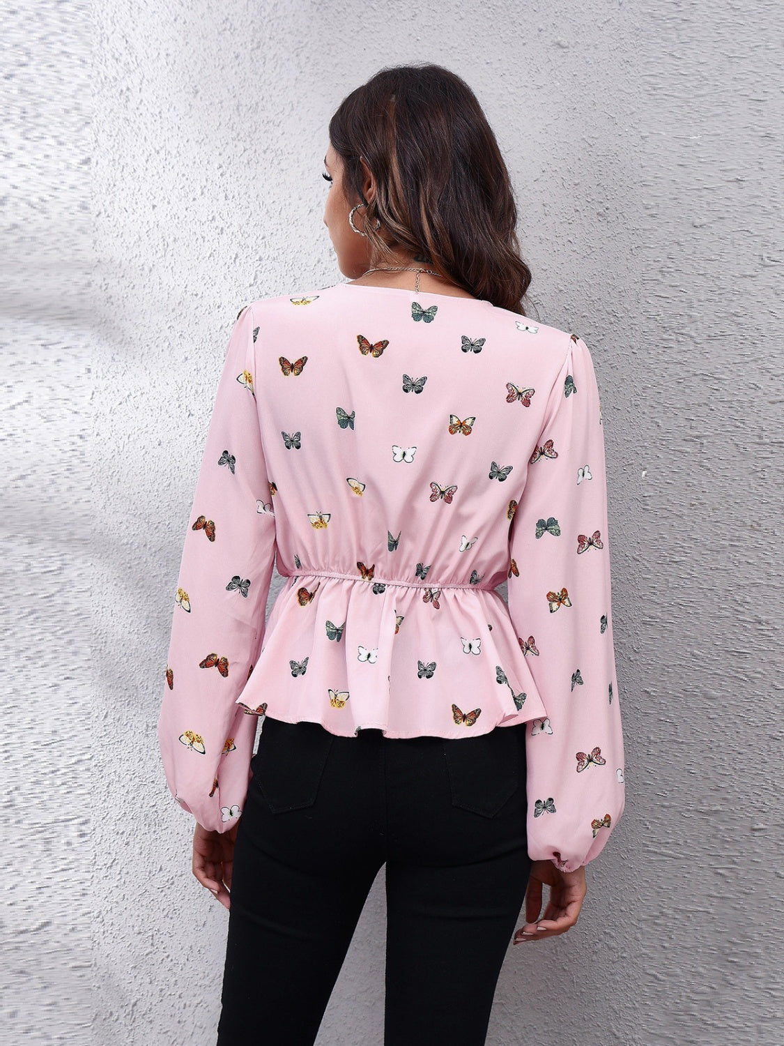 Dusty pink peplum blouse with gathered waist and allover butterfly print.