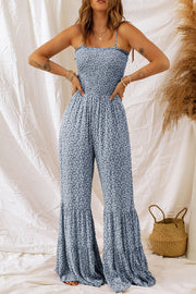 Dark blue floral smocked bodice spaghetti strap jumpsuit with flare legs.