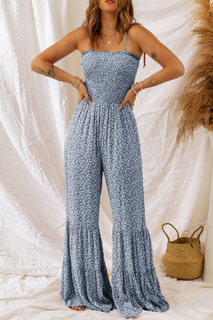 Dark blue floral smocked bodice spaghetti strap jumpsuit with flare legs.