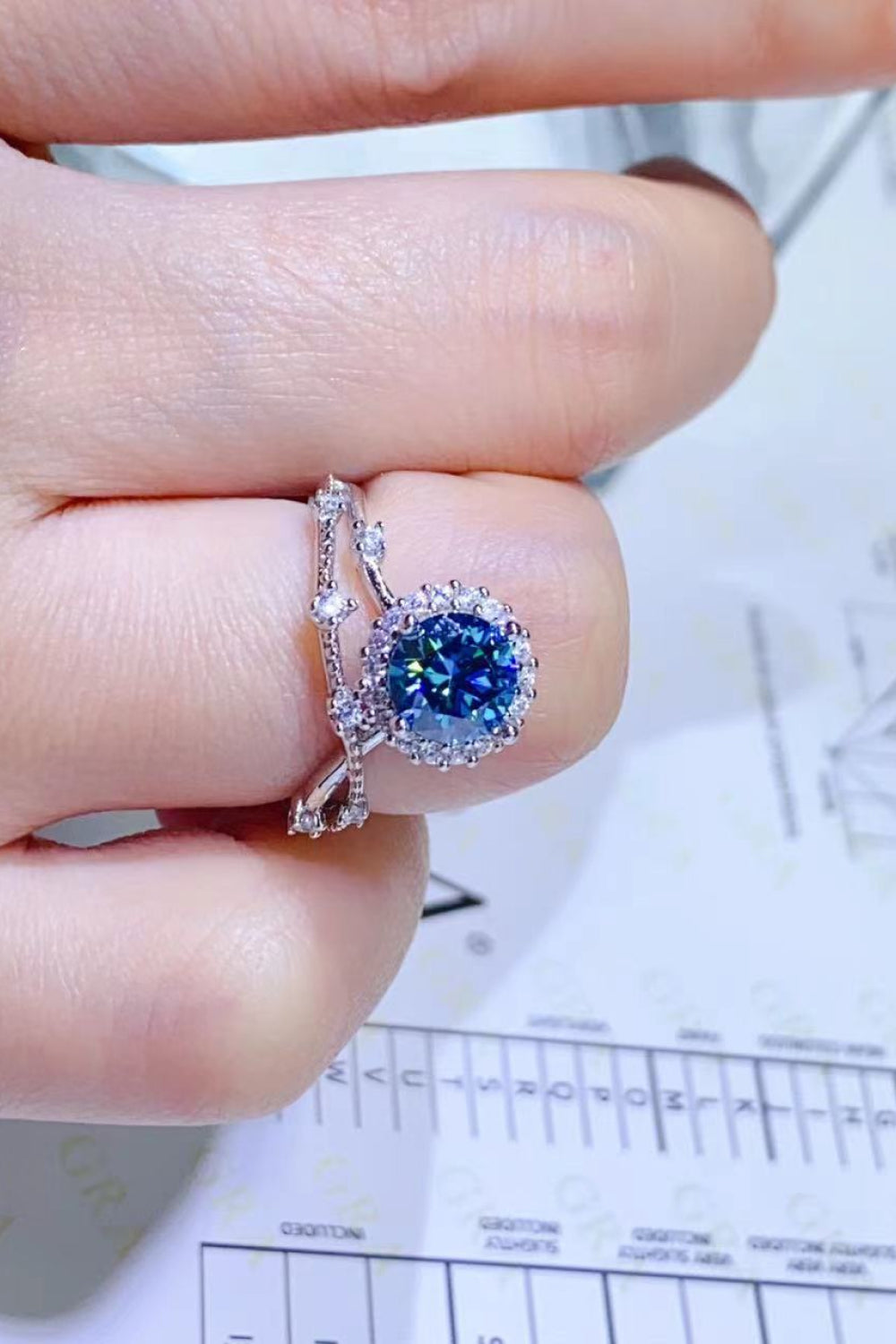 Sky blue moissanite engagement ring set with halo and diamond band.
