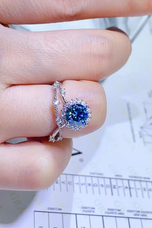 Sky blue moissanite engagement ring set with halo and diamond band.