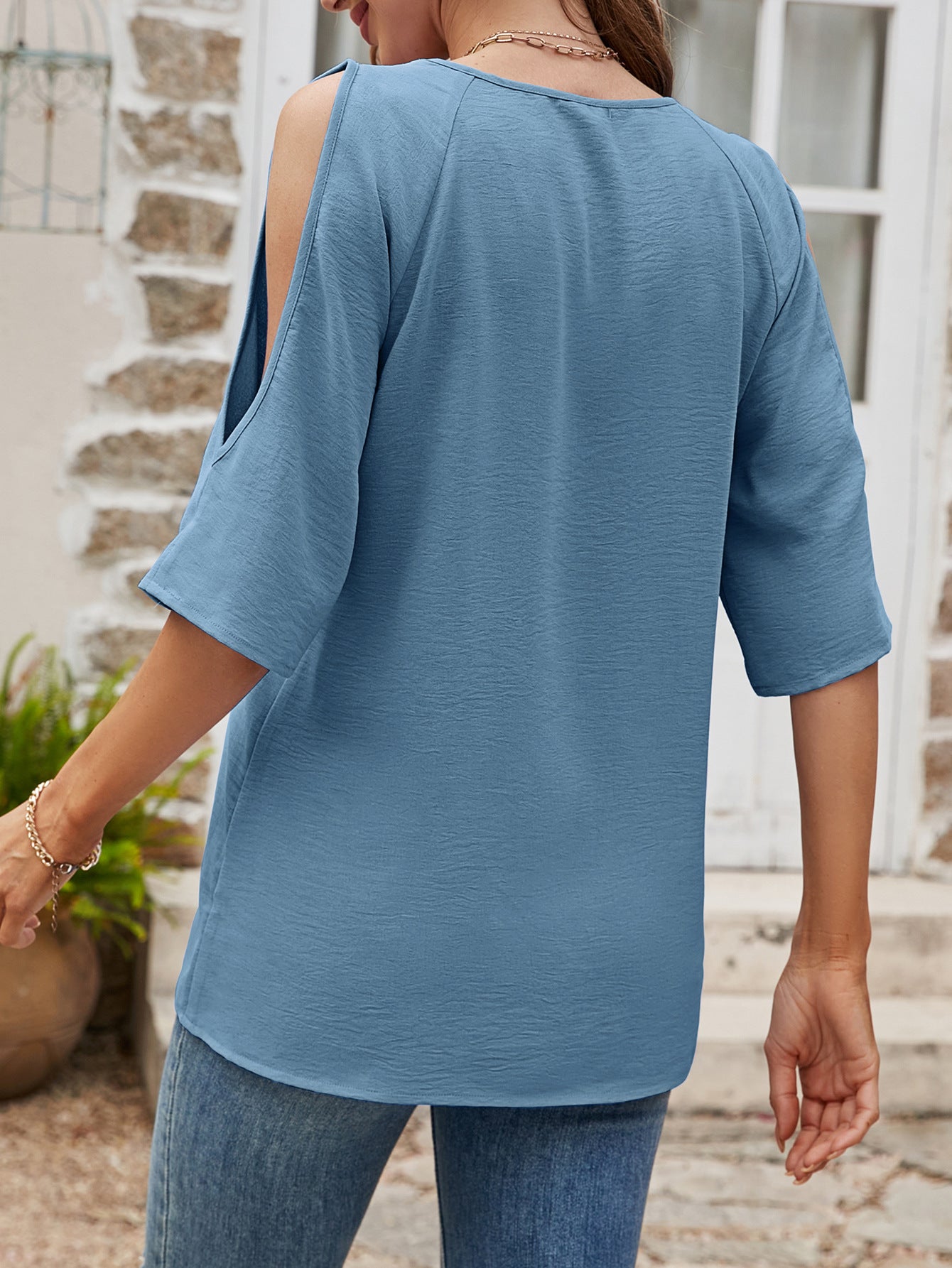 Light blue textured open-shoulder raglan top with short sleeves.