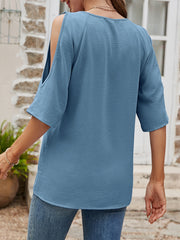 Light blue textured open-shoulder raglan top with short sleeves.