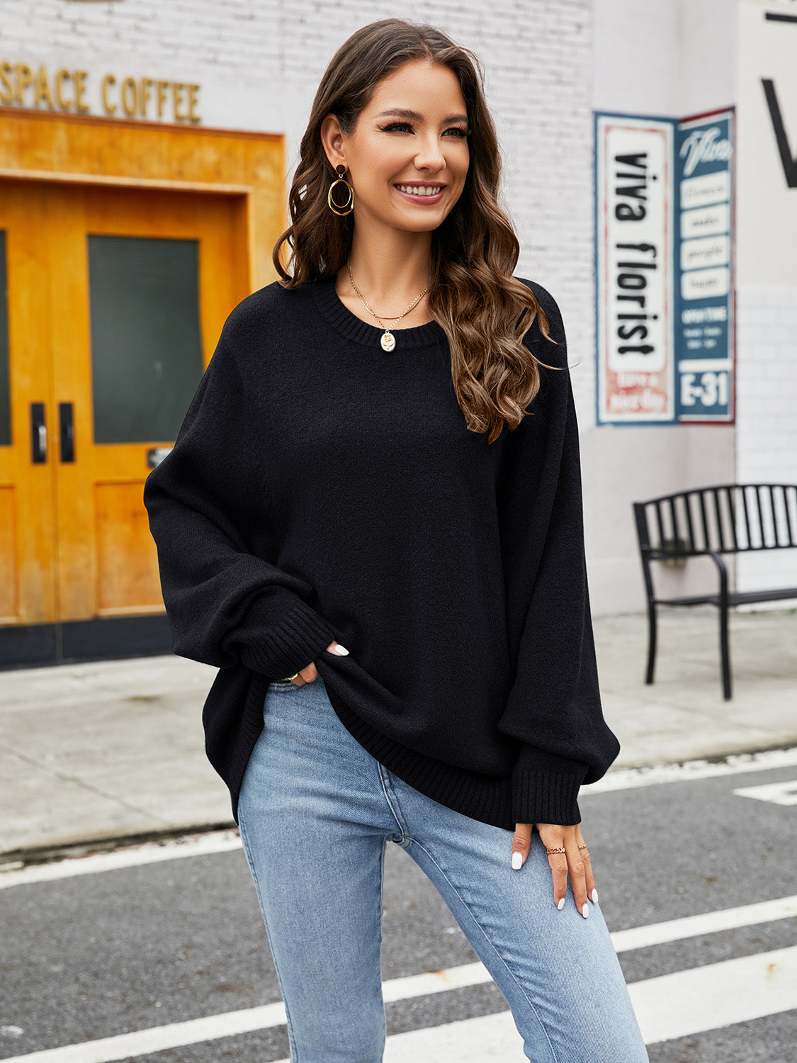 Black acrylic crewneck sweater with balloon sleeves and ribbed cuffs, styled with jeans.