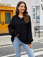 Black acrylic crewneck sweater with balloon sleeves and ribbed cuffs, styled with jeans.