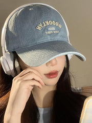 Light blue baseball cap with embroidered Brooklyn text and a white headband.