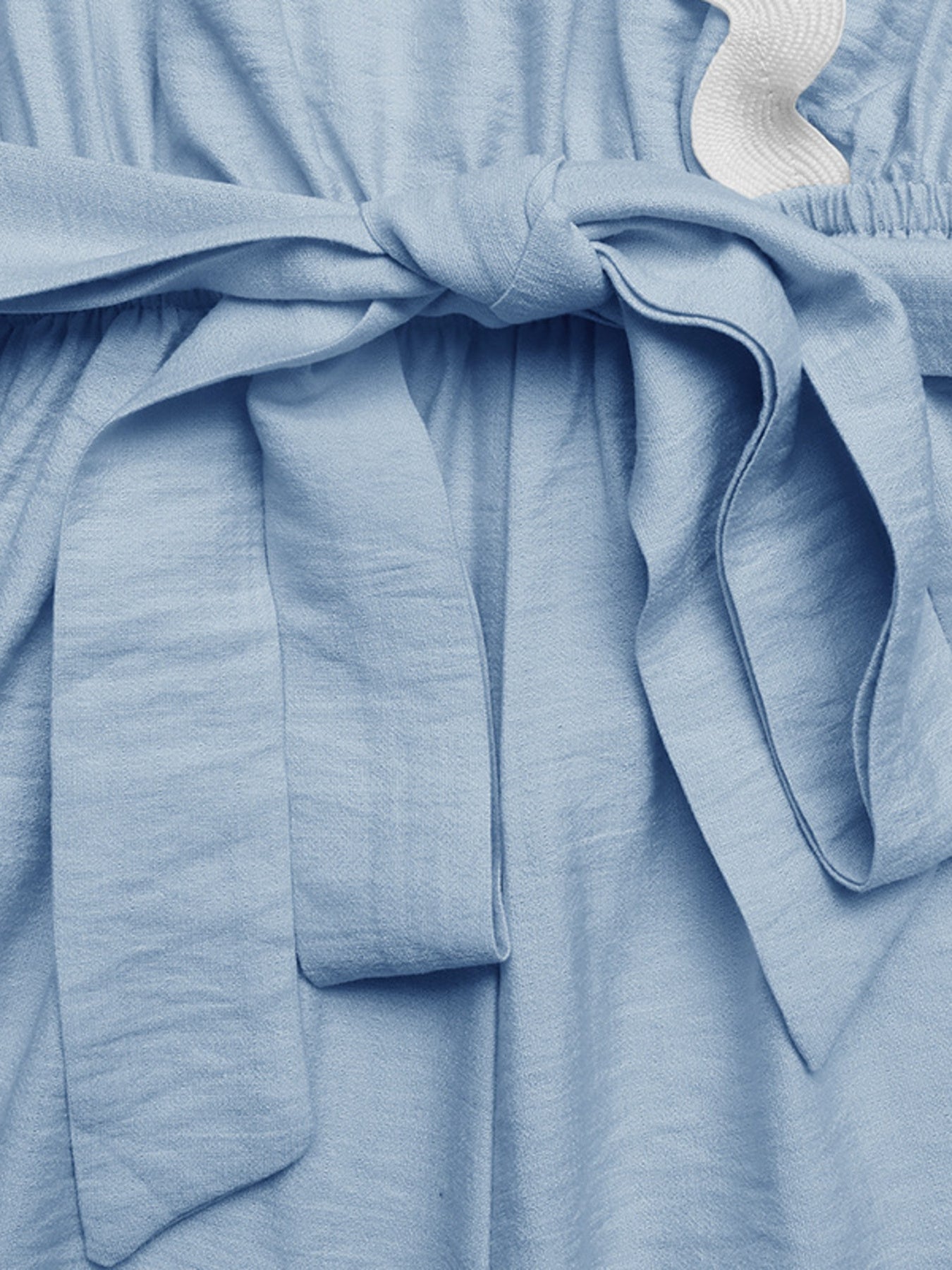 Blue maternity wrap romper with tie waist and scalloped trim detail.