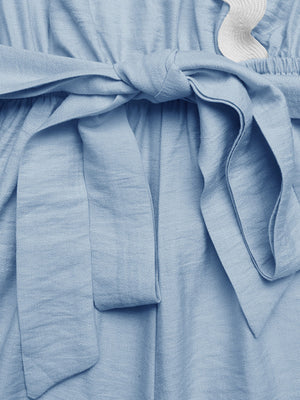 Blue maternity wrap romper with tie waist and scalloped trim detail.