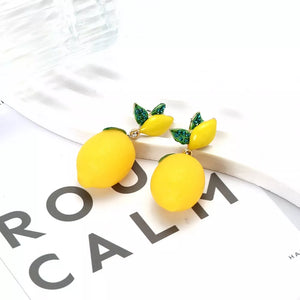 Gold-plated drop earrings with yellow lemon charms and green jeweled leaves.