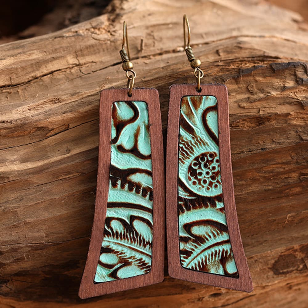Tooled leather and wood drop earrings with turquoise and brown floral pattern.