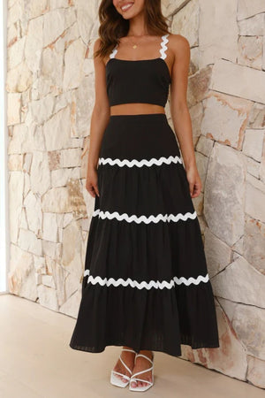 Black crop top with scalloped white trim and tiered maxi skirt with white scalloped trim.