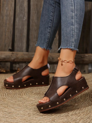 Brown cutout studded platform sandals with ankle strap and open toe.