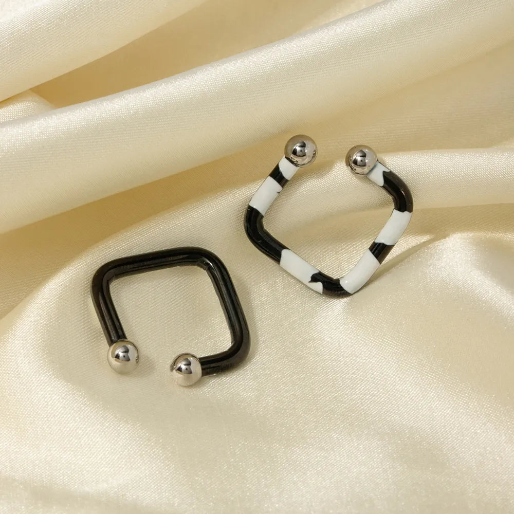 Geometric zebra stripe ear cuffs in black and white with silver ball ends.