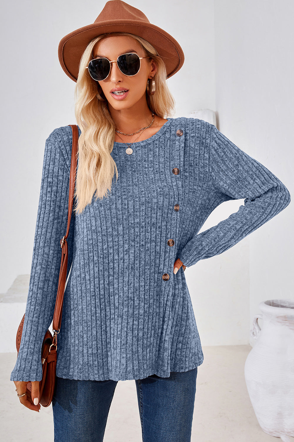 Dusty blue ribbed knit sweater with asymmetric button detail and long sleeves.