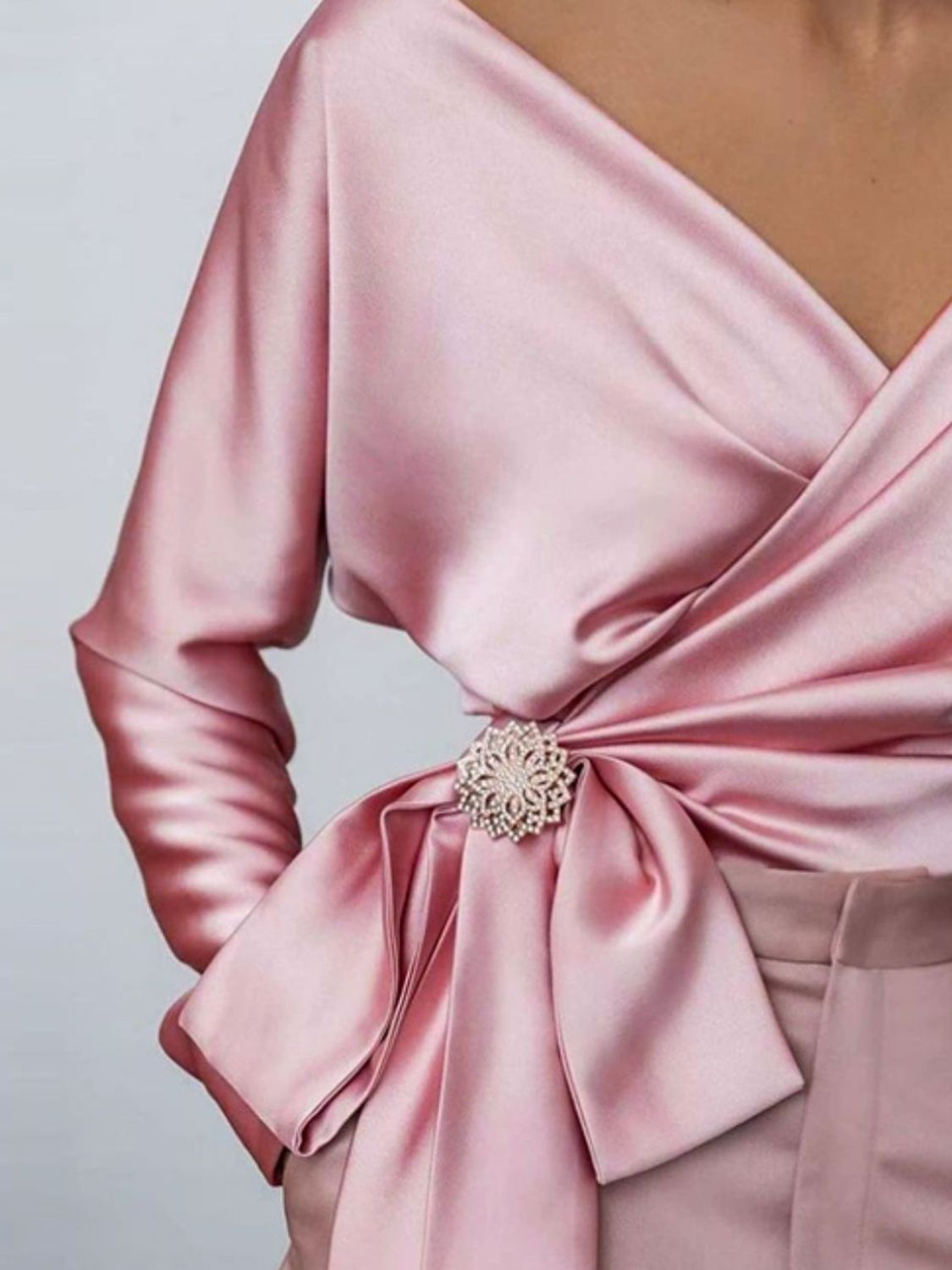 Blush pink satin blouse with draped detail and crystal brooch