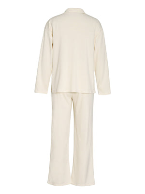 Cream ribbed knit lounge set with relaxed fit long sleeve top and wide leg pants.