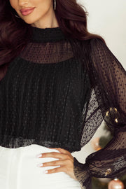 Black sheer mock neck blouse with textured dot pattern and pleated details.