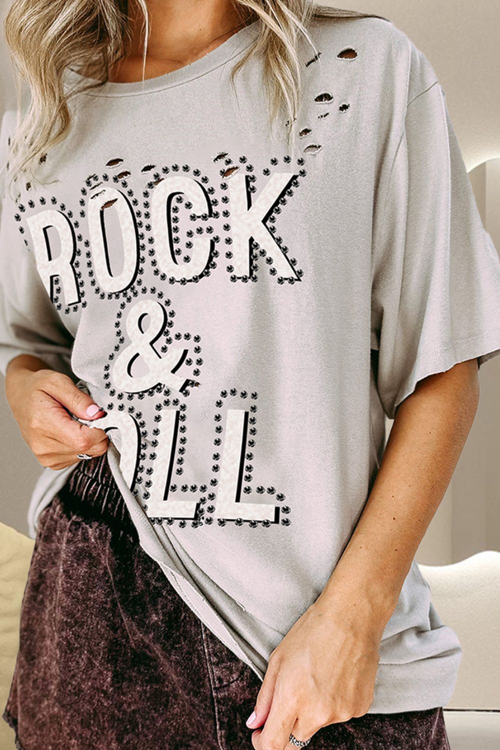 Light gray distressed cotton t-shirt with "ROCK & ROLL" graphic and studded details.